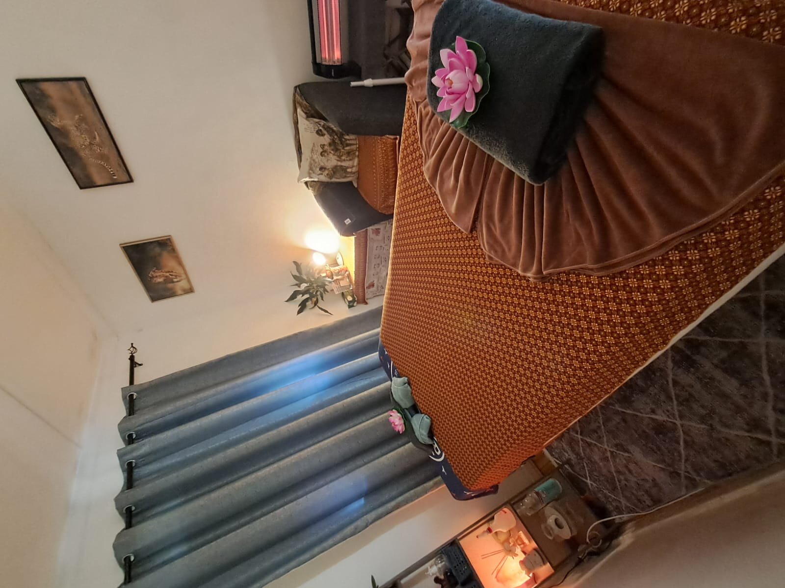 Warmly lit treatment room with a second massage bed and soft towels